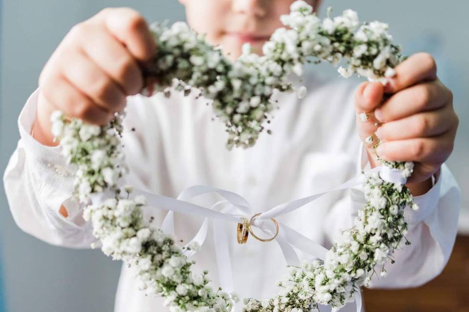  alianças de casamento menino segurando coração de flores e alianças